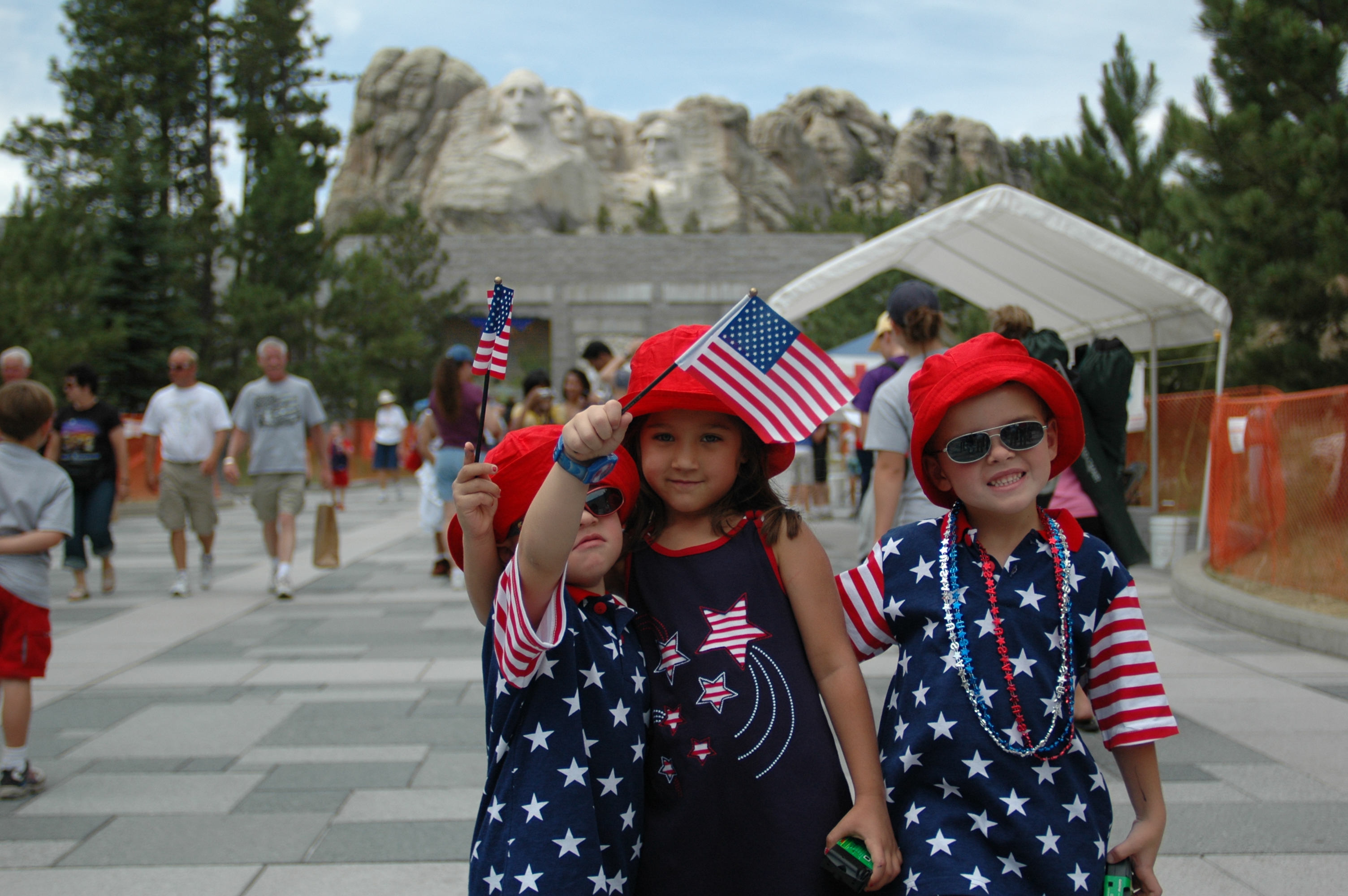 Patriotic children at Mount Rushmore waving flags